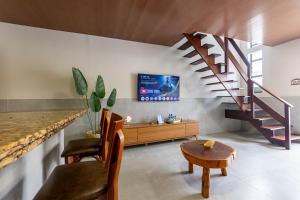 a living room with a staircase and a table at Casa06Frances com decoração moderna à 8min de carro da praia do frances com piscina PRIVATIVA, 03 quartos com AR in Marechal Deodoro