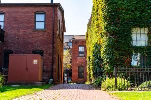 an ivycovered brick building with a brick walkway next to a building at The Inn Down Town in Erie