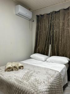 a bed with a stuffed animal laying on top of it at Pousada Pampeano in São Gabriel +13 photos