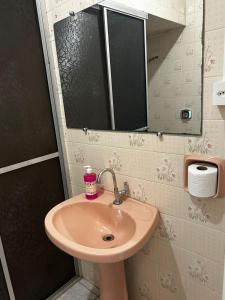 a bathroom with a sink and a mirror at Pousada Pampeano in São Gabriel