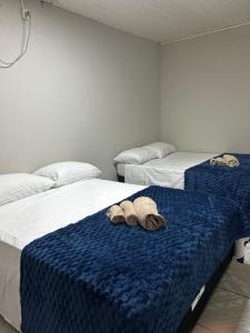 a room with two beds with towels on them at Pousada Pampeano in São Gabriel