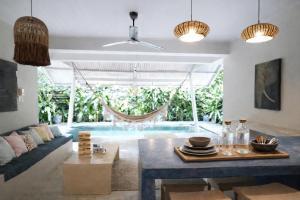 a living room with a couch and a hammock at Sleepy Gypsea Villa Siargao in Siargao Island