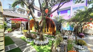 a courtyard with a tree and chairs and a building at Mi Lan Villa Hotel in Vung Tau