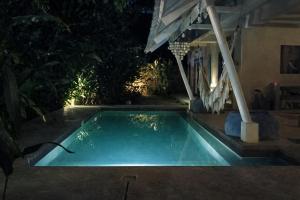 a swimming pool in a backyard at night at Sleepy Gypsea Villa Siargao in Siargao Island