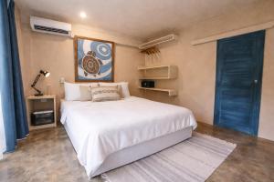 a bedroom with a white bed and a blue door at Sleepy Gypsea Villa Siargao in Siargao Island +59 photos
