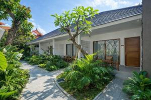 a house with a garden and a walkway at Casa Wina Kuta by The Wina Resorts in Kuta
