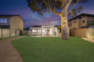 a house with a tree in the yard at Casa Esperanza by Experience Jervis Bay in Vincentia +8 photos