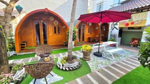 a house with a garden with a table and an umbrella at Milan Corner Hotel in Vung Tau