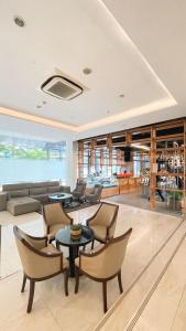 a living room with a couch and tables and chairs at Luxury Inn Arion Hotel in Jakarta