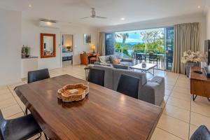 a living room with a dining table and a couch at Blue Water Views on Hamilton Island by HIHA in Hamilton Island