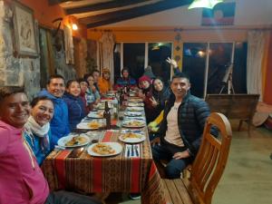 a group of people sitting around a long table at Inkapacha ecohostel cabañas in Comunidad Yumani