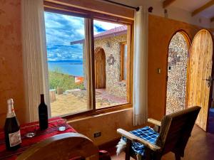 a room with a window with a view of the ocean at Inkapacha ecohostel cabañas in Comunidad Yumani +6 photos