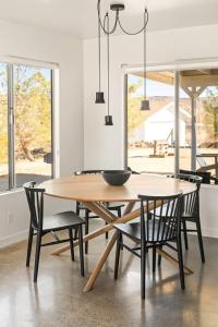 a dining room with a wooden table and chairs at The Sawtooth House - Pioneertown Escape with Pool, Spa, Views & Fire Pit in Pioneertown