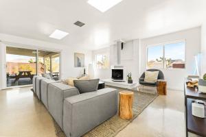 a living room with a gray couch and a table at The Sawtooth House - Pioneertown Escape with Pool, Spa, Views & Fire Pit in Pioneertown