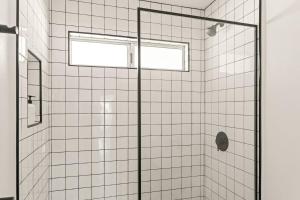 a bathroom with a shower with a glass door at The Sawtooth House - Pioneertown Escape with Pool, Spa, Views & Fire Pit in Pioneertown +57 photos