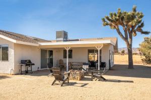 a house with chairs and a table and a piano at The Sawtooth House - Pioneertown Escape with Pool, Spa, Views & Fire Pit in Pioneertown