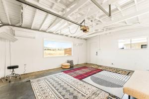 a white room with a rug on the floor at The Sawtooth House - Pioneertown Escape with Pool, Spa, Views & Fire Pit in Pioneertown