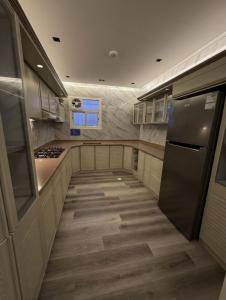 a large kitchen with wooden floors and stainless steel appliances at شقة الخليل in Quai