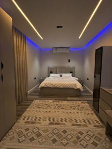 a bedroom with a large bed with blue lights at شقة الخليل in Quai