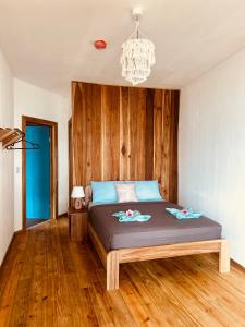 a bedroom with a bed with a wooden wall at Blue Marlin in Bocas Town