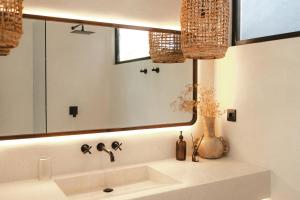a bathroom with a sink and a large mirror at Tyde Bali Boutique Hotel in Uluwatu