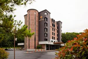 a large brick building with a car parked in a parking lot at Hotel The Star in Yeonggwang