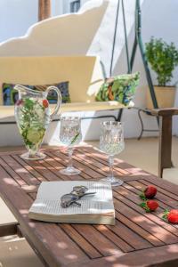 a wooden table with glasses and strawberries on it at Casa de Flores 2 in Plaka Milou