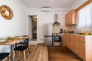 a kitchen with wooden floors and stainless steel appliances at Casa de Flores 2 in Plaka Milou +31 photos