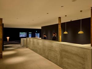 a lobby with two people standing at a counter at ONCRI-Karatsu おんくり唐津 in Karatsu