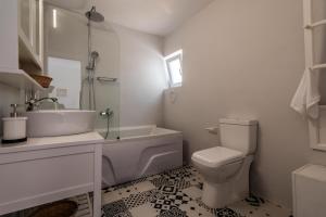 a white bathroom with a sink and a toilet at Casa de Flores 2 in Plaka Milou
