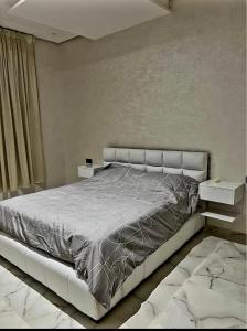 a bedroom with a large bed and two tables at Massira 2 in Taza