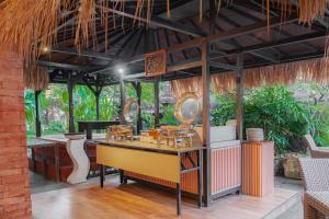 a restaurant with a table and chairs in a building at Casa Wina Kuta by The Wina Resorts in Kuta
