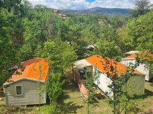 a group of buildings with orange roofs in a forest at Chalet 4 Pers - Terrasse - API-1-52-1751 in Espira-de-Conflent