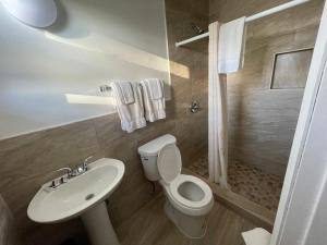 a bathroom with a white toilet and a sink at Shangri La Motel in Ocala