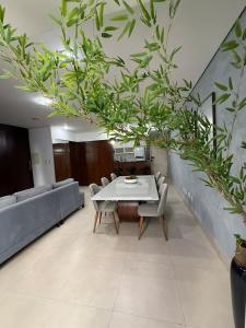 a dining room with a white table and chairs at Sublime Mognos Apartment - Bosque Saúde in Cuiabá