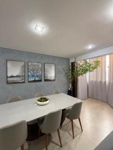 a dining room with a white table and chairs at Sublime Mognos Apartment - Bosque Saúde in Cuiabá