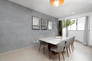 a dining room with a white table and chairs at Sublime Mognos Apartment - Bosque Saúde in Cuiabá
