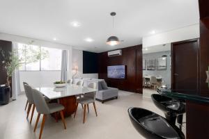 a kitchen and living room with a table and chairs at Sublime Mognos Apartment - Bosque Saúde in Cuiabá