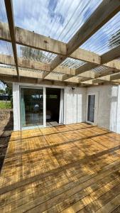 a wooden deck with a pergola on a house at Gosling Grove Hideaway in Turangi