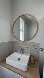 a bathroom with a white sink and a mirror at Gosling Grove Hideaway in Turangi +7 photos