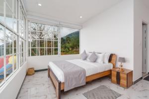 a bedroom with a bed and a large window at Villa Rosaria - Framed by Nature, Finished with Luxury in Beragala