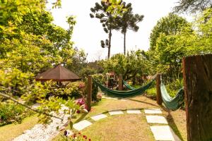 a garden with hammocks and a gazebo at Pousada das Hortênsias in Campos do Jordão
