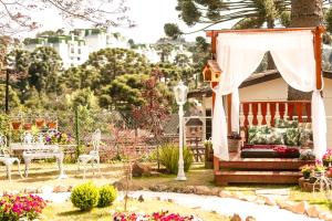 a house with a gazebo in a garden at Pousada das Hortênsias in Campos do Jordão