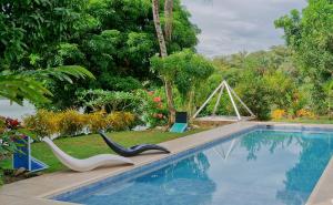 a swimming pool with a pair of chairs next to it at casa Lucerna in Prado +7 photos