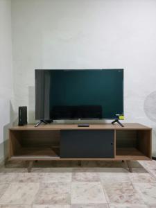 a flat screen tv sitting on a wooden entertainment center at Merida Centro House with Private Pool and Air Conditioning in Mérida