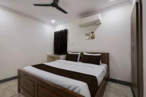 a bedroom with a large bed with a ceiling fan at Hotel CJ Grand Vijayawada in Vijayawāda