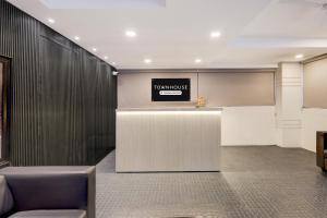 a lobby with a reception desk with a sign on the wall at Hotel CJ Grand Vijayawada in Vijayawāda