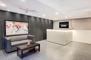 a lobby with a waiting room with a couch and a table at Hotel CJ Grand Vijayawada in Vijayawāda