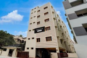 a tall white building with a sign on it at Hotel CJ Grand Vijayawada in Vijayawāda