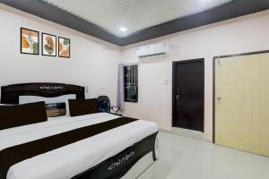 a bedroom with a large bed and a door at Hotel O Shri Buddheshwar Temple Lucknow in Alambagh
